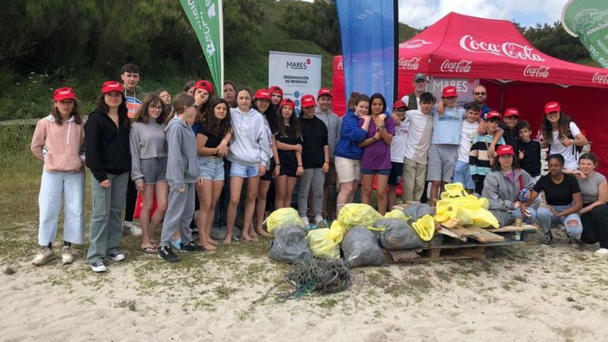 Casi 40 voluntarios del instituto coruñés Urbano Lugrís limpian la playa de Malpica