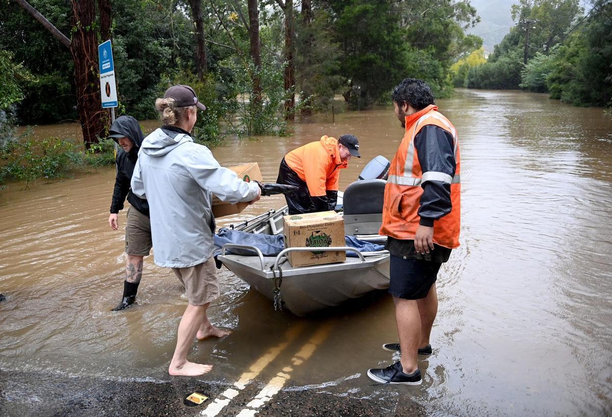 Sydney (Australia), 05/07/2022.- Local residents transport fuel and supplies across the flooded streets on small boats to stranded residents that are cut off by floodwaters which have inundate the town of Yarramalong on the Central Coast, North of Sydney, New South Wales, Australia, 05 July 2022. New South Wales residents are bracing for more heavy rain and flooding as dangerous downpours continue throughout the day. EFE/EPA/JEREMY PIPER AUSTRALIA AND NEW ZEALAND OUT