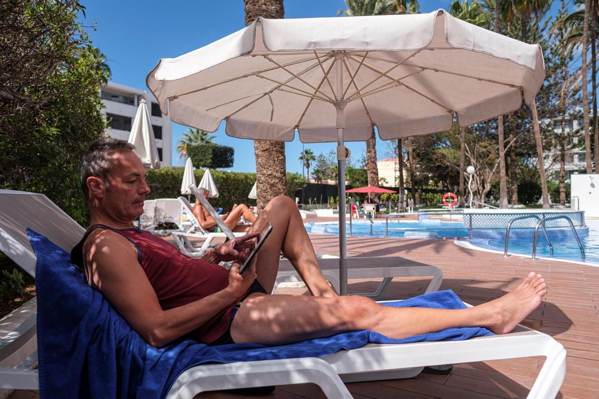 Un huésped disfruta del sol en la piscina de un hotel de las Islas.