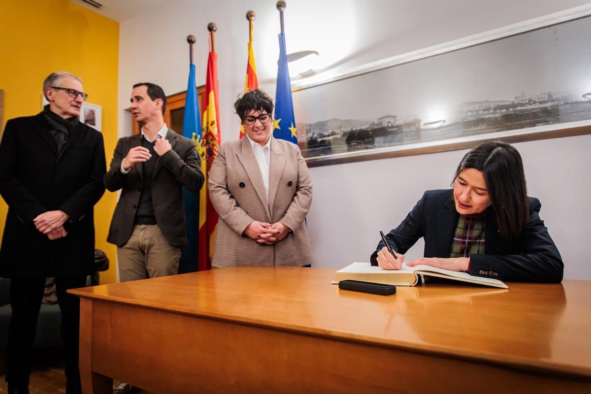 El Secretario General de Interior, Tomás Carrión, el primer teniente de Alcaldía, Toni Suárez y la alcaldesa González acompañan a Parlon mientras firma el libro de honor del Ayuntamiento de Santa Coloma
