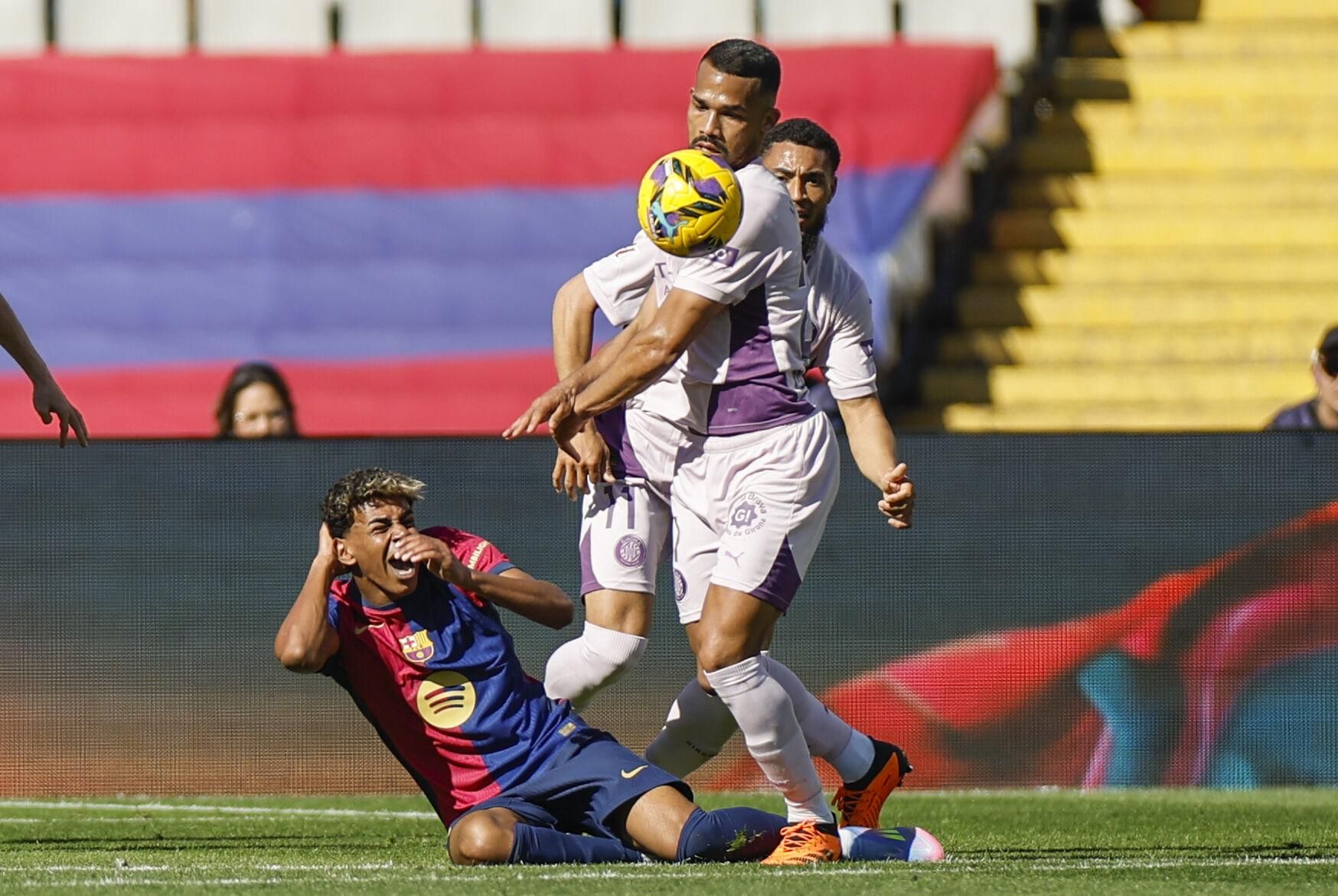 BARCELONA, 30/03/2025.- El delantero del Barcelona Lamine Yamal, y el centrocampista del Girona Yangel Herrera (d), durante el partido de la jornada 29 de LaLiga que FC Barcelona y Girona disputan este domingo en el estadio Lluis Companys de Barcelona. EFE/ Alberto Estévez