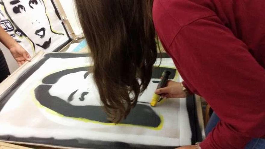 Una participante realiza un retrato con la técnica del stencil. // Marta G. Brea