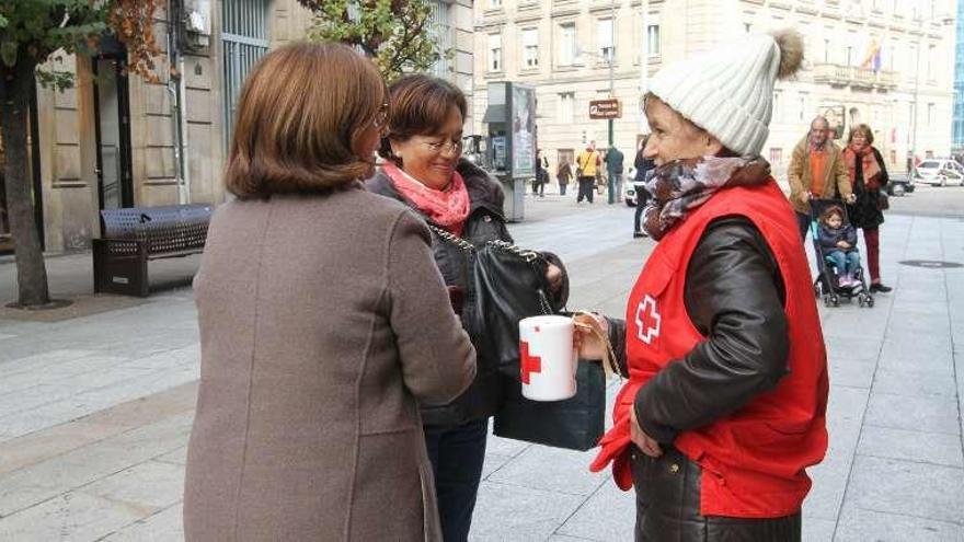 Dos mujeres entragan un donativo a una voluntaria. // Iñaki Osorio