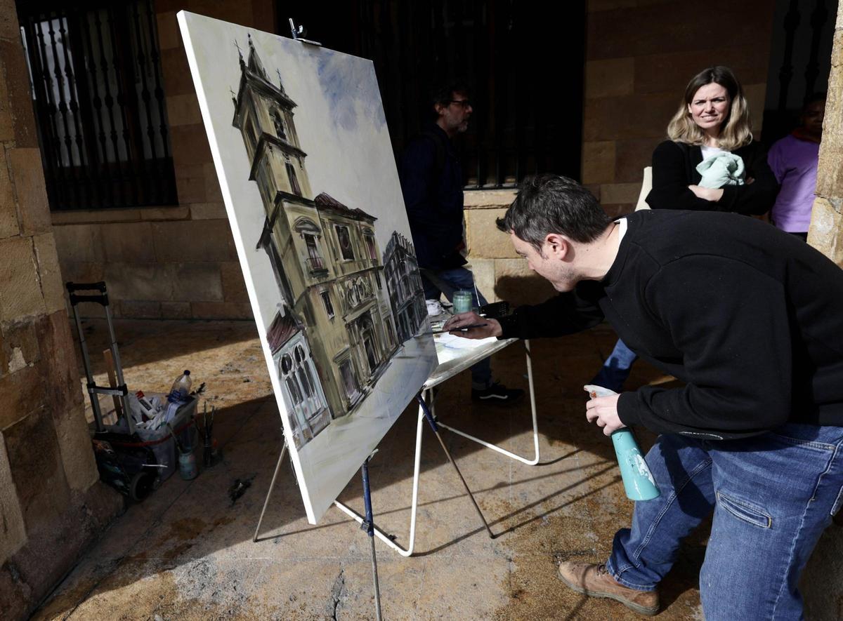 Un participante en el concurso pinta la iglesia de San Isidoro en los soportales del Ayuntamiento.