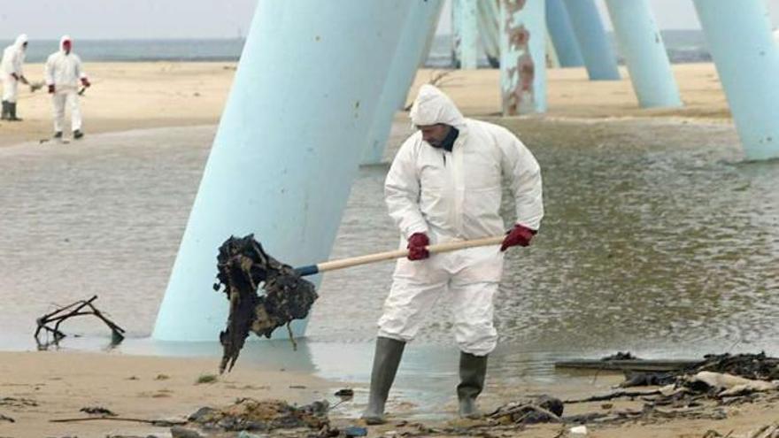 Voluntarios limpian el fuel en una playa de Francia después del accidente del &#039;Prestige&#039;. / michel gangne