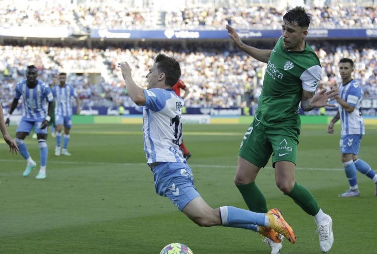 El malaguista Aleix Febas cae derribado por ratiu en el partido ante el Huesca.