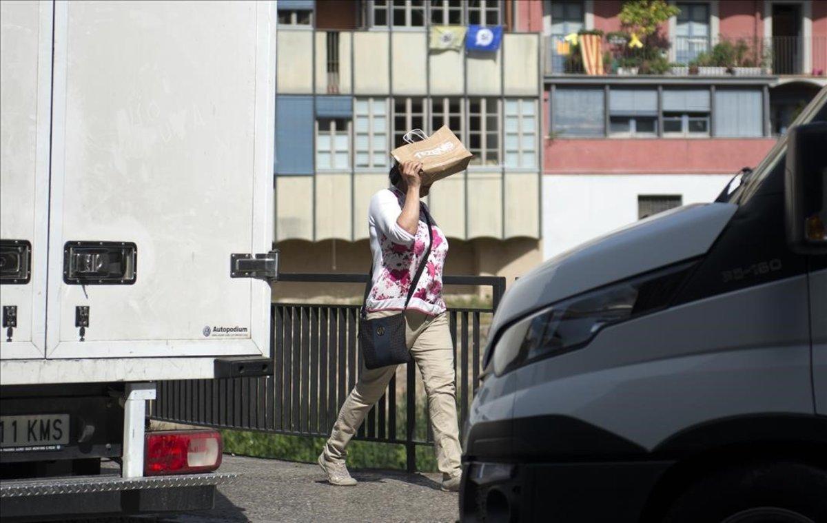 Una mujer se protege del calor en Girona.