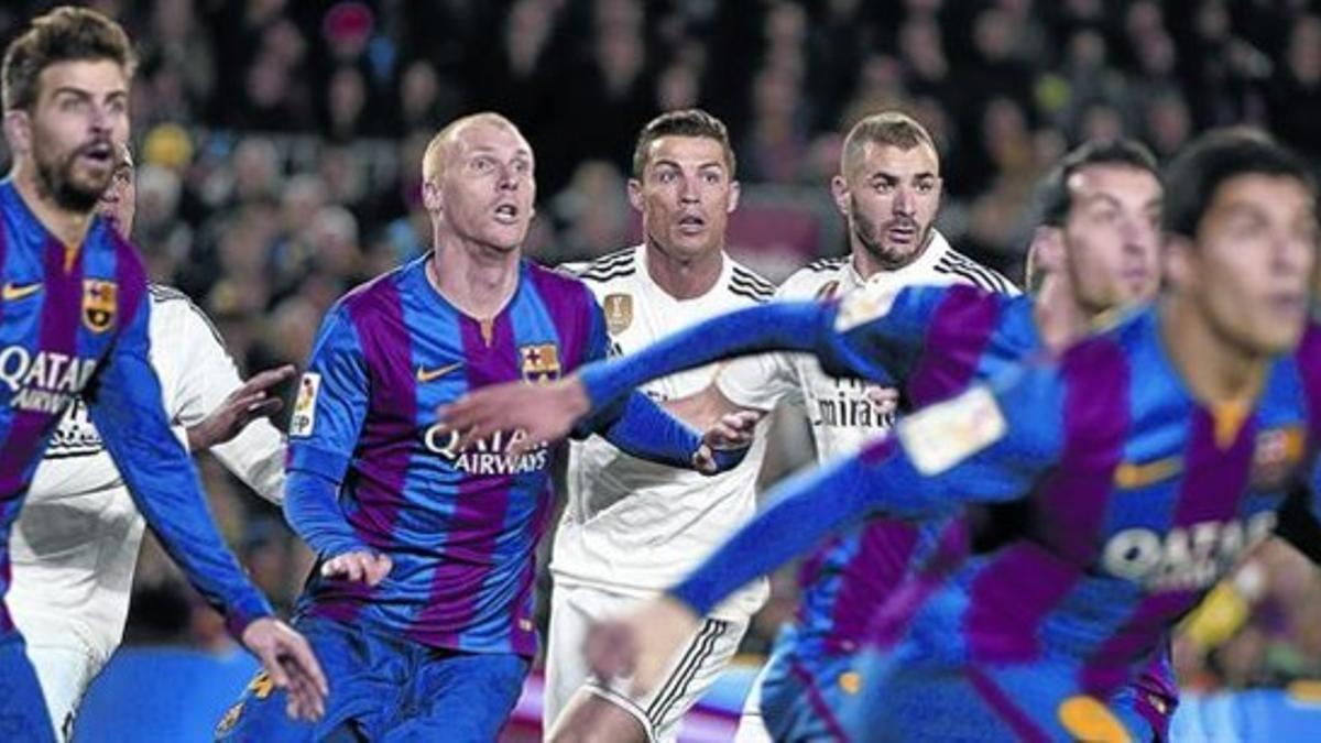 Los jugadores del Barça y el Madrid, muy atentos en un saque de córner, en el clásico de ayer en el Camp Nou.