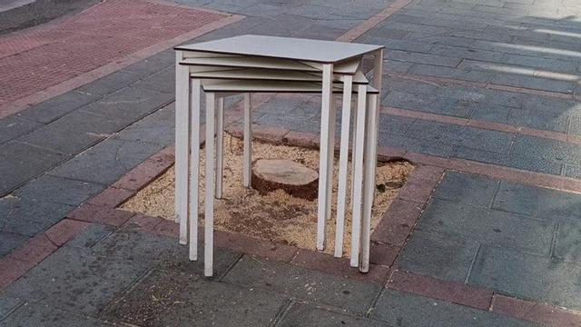 Mesas amontonadas ocupan el alcorque que albergaba uno de los árboles del centro urbano de Marbella.