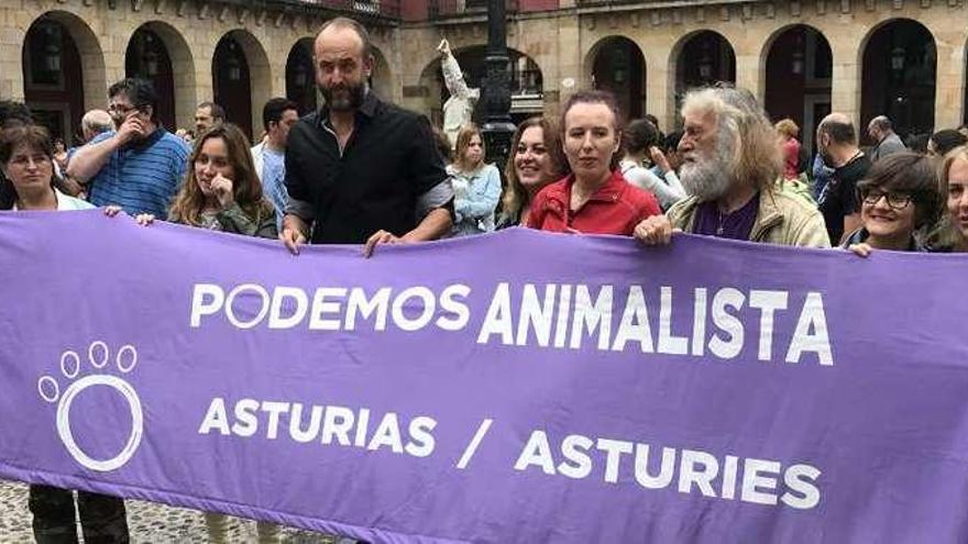 Varios representantes de Podemos sostienen una pancarta, con David Alonso, concejal de Xixón Sí Puede en el Ayuntamiento de Gijón, en el centro.