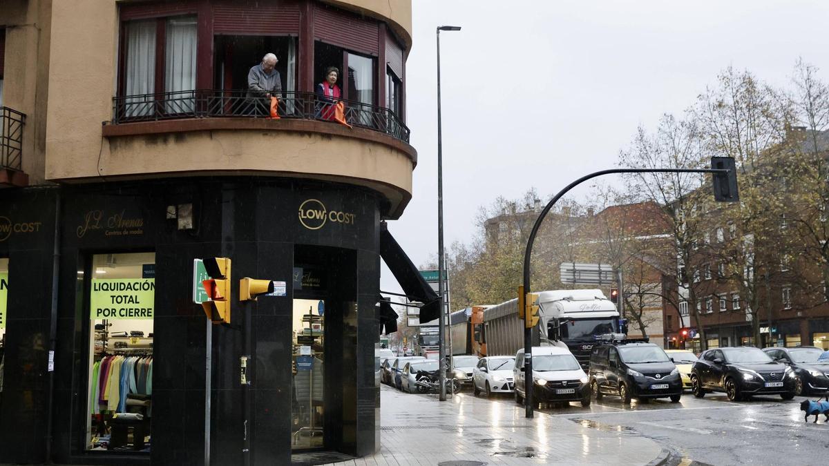 Camiones pasando por Cuatro Caminos, con los vecinos colgando telas naranjas denunciando la situación.