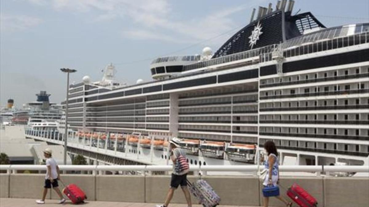 Unos viajeros desembarcan de un crucero en Barcelona, este verano.