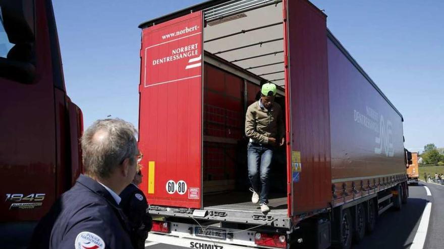 Un inmigrante baja de un camión en Calais tras ser sorprendido.