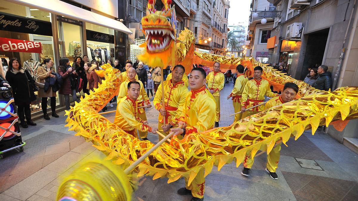 Varias personas de origen chino realizan una danza del dragón durante una celebración en Elche.