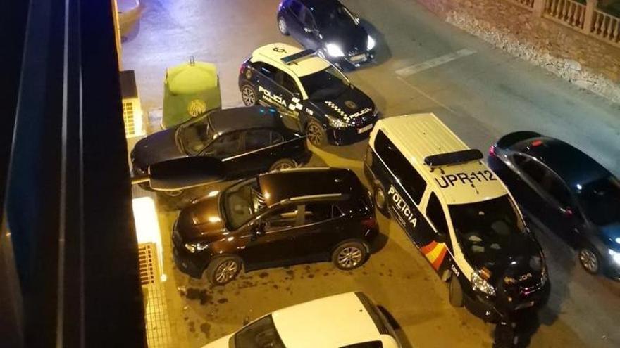 Varios coches de Policía, apostados frente a la puerta de uno de los locales que han sido registrados