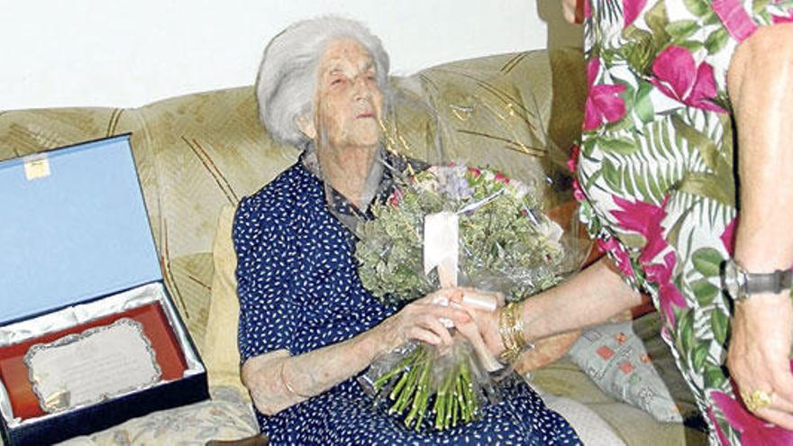 La centenaria recibe un obsequio de la asociación de Personas Mayores.