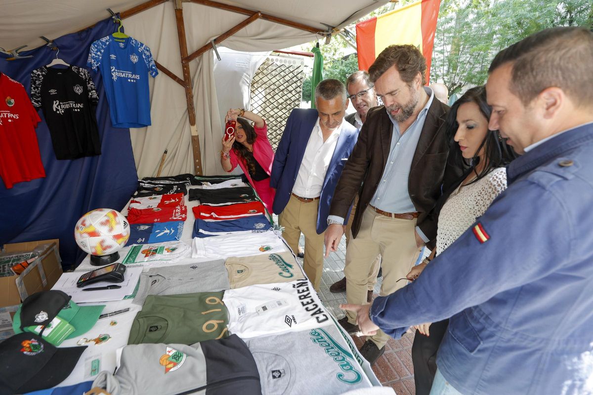 La comitiva de Vox en el puesto de camisetas del Cacereño, esta mañana en Cáceres.
