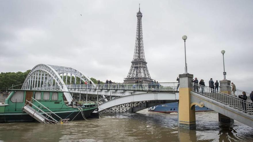 Varias personas observan ayer el río Sena que va muy crecido en París.