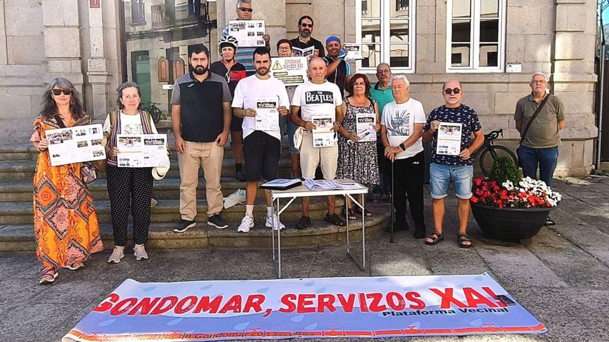 Representantes da plataforma veciñal, coa revista diante do Concello.