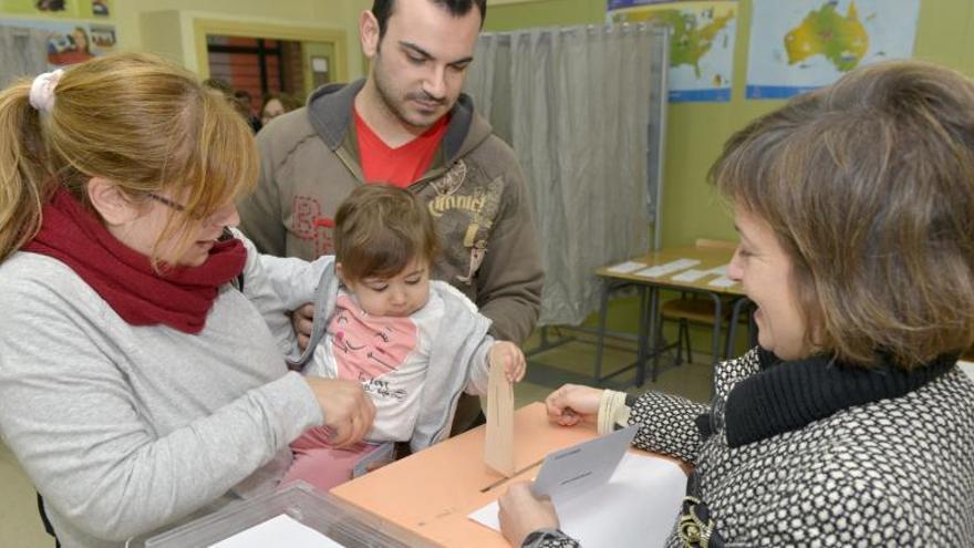 Una niña mete en la urna el voto de su madre