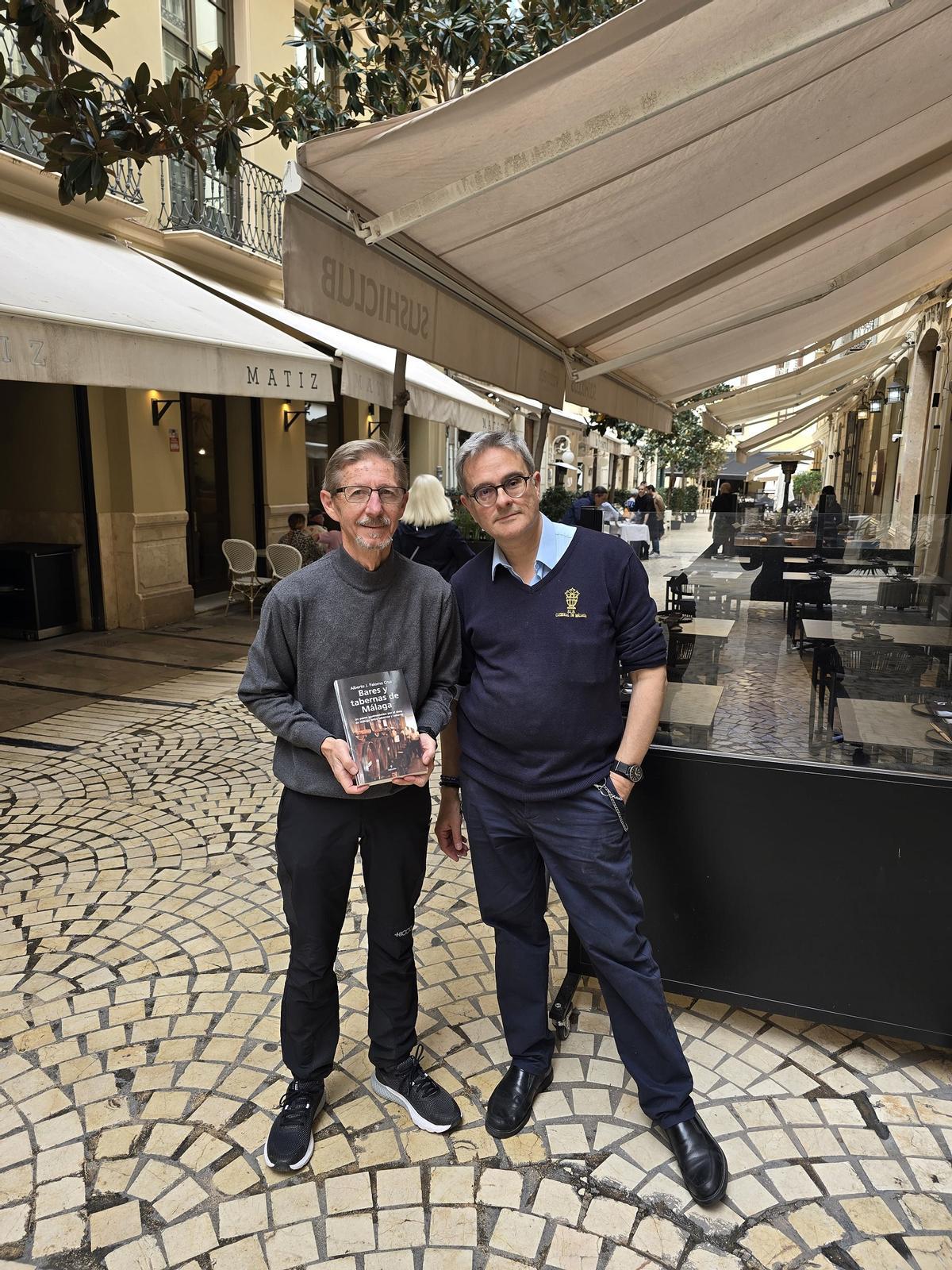 El fotógrafo Juan Miguel Salvador y Alberto Palomo, junto a restaurantes de calle Strachan con su libro, esta semana.