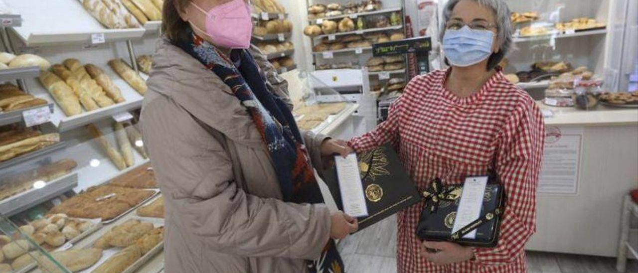 Margot Rodríguez entrega los marcapáginas a Emi García.