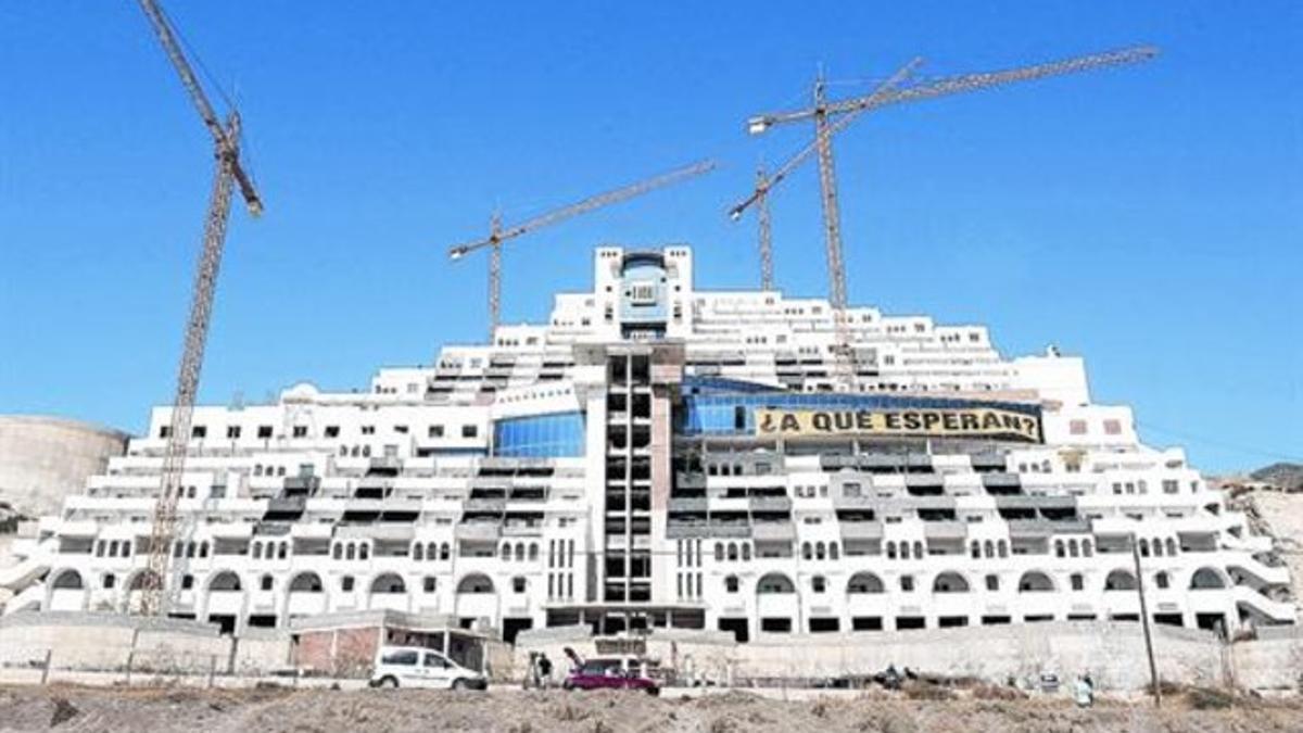 El hotel inacabado del Algarrobico, en la playa almeriense de Carboneras, con una pancarta que llama a su demolición, en el 2012.