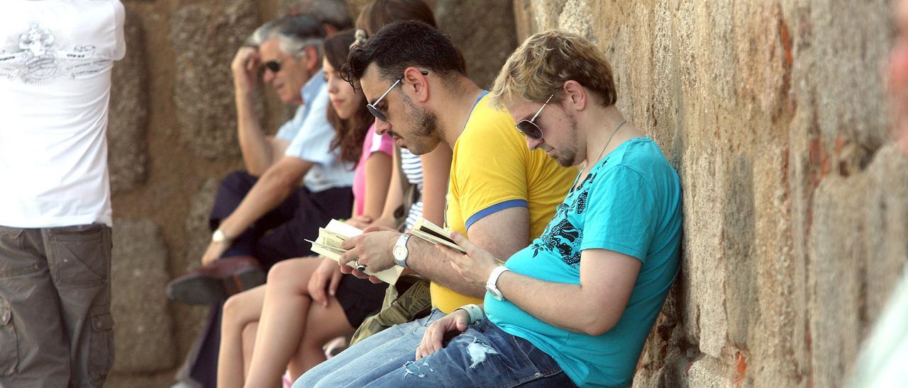 Un grupo de turistas resguardados a la sombra en Mérida.