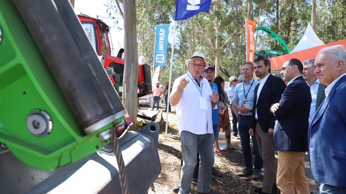 Un técnico explica las novedades técnicas en maquinaria silvícola a las autoridades presentes en Galiforest, Boqueixón