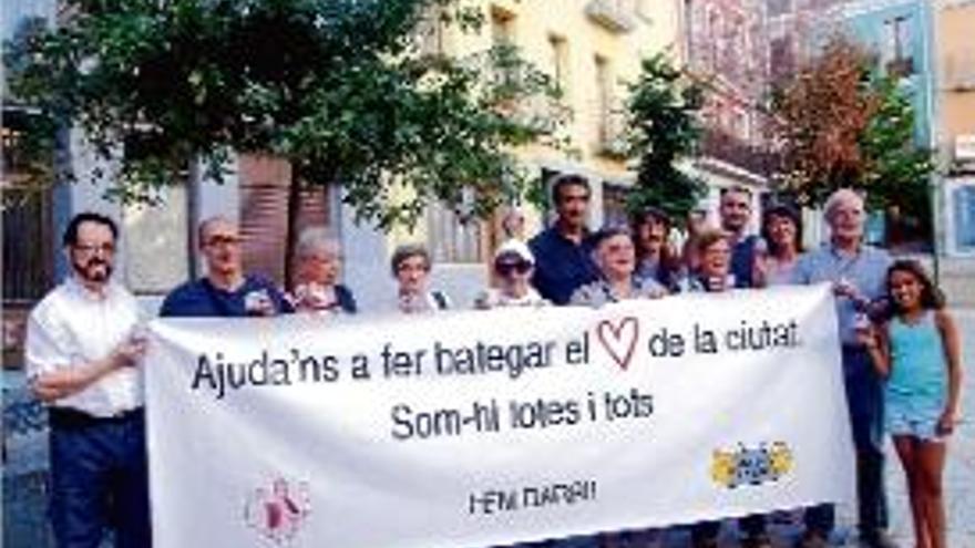 Veïns del barri vell amb la pancarta i les capses de runa .