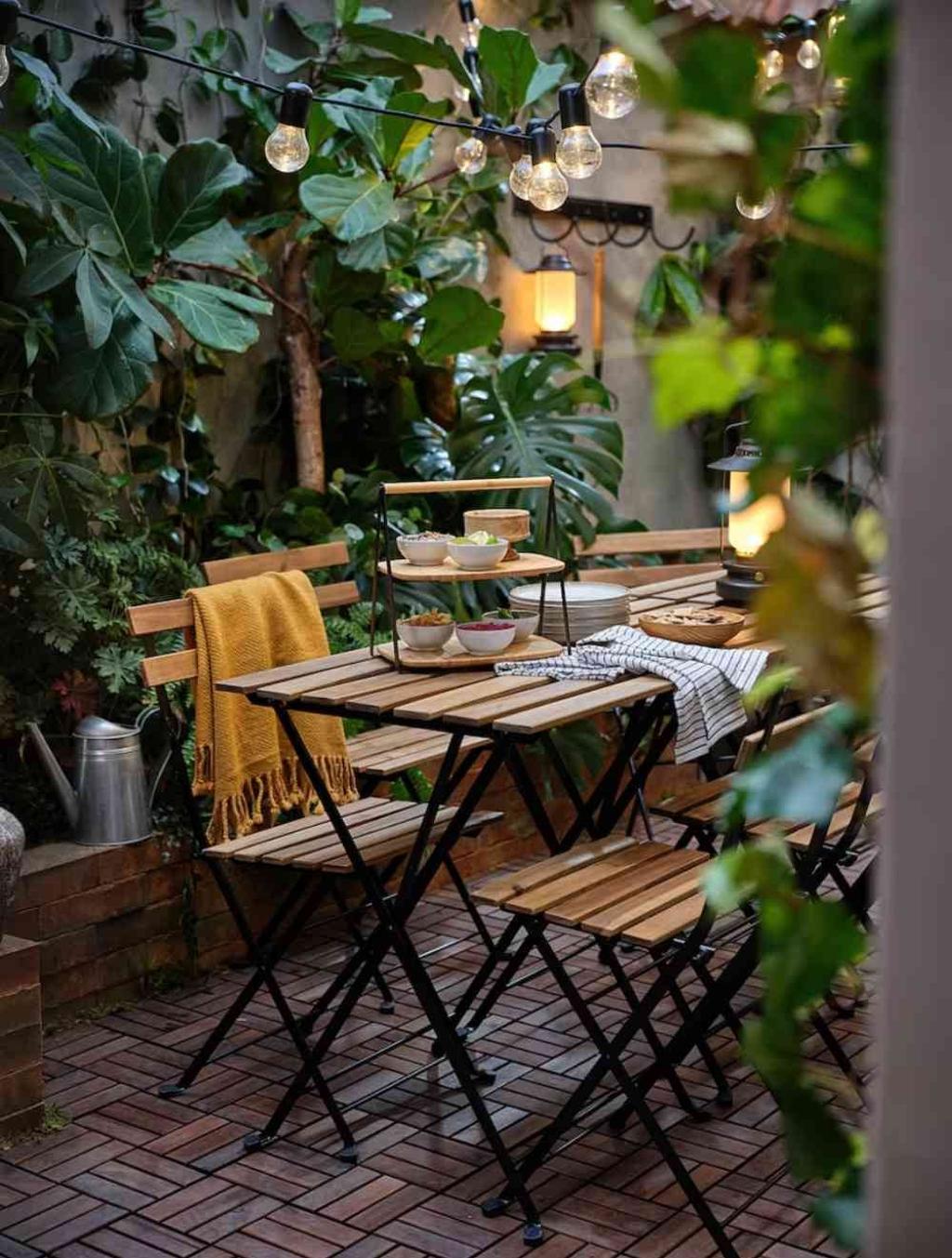 Patio con mesa de madera y bandeja de bambú de dos pisos de Ikea