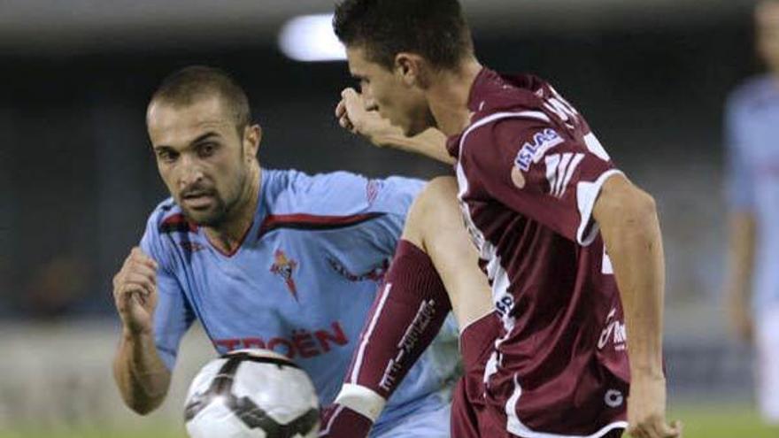 El jugador del Celta de Vigo, Bustos (i), lucha un balón con el jugador del Tenerife, Omar ,durante el partido de dieciseisavos de final de la Copa del Rey que los dos equipos juegan, esta noche, en el estadio de Balaídos, en Vigo.