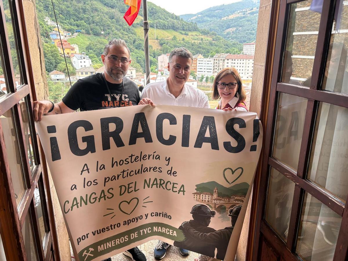 Por la izquierda, Carlos Menéndez, José Luis Fontaniella y Carmen Martínez con la pancarta de agradecmiento de los mineros de Tyc Narcea.