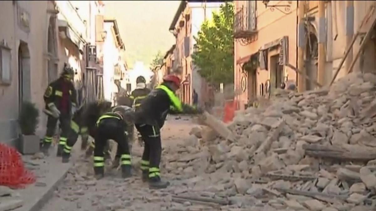 Bomberos buscan entre los escombros en Norcia.