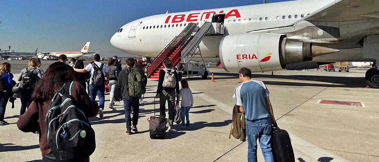 Pasajeros de un vuelo de Iberia con salida en Madrid y destino en Canarias en un momento del embarque. | | EFE