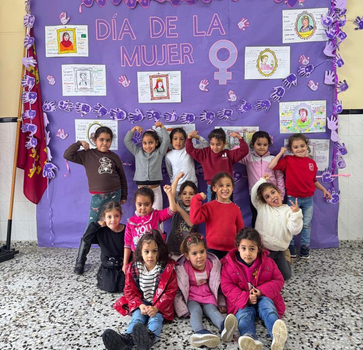 Dos grupos de alumnas posan junto al mural que compusieron  sobre mujeres importantes de la historia y que se podía ver en la entrada del colegio. | L.O.