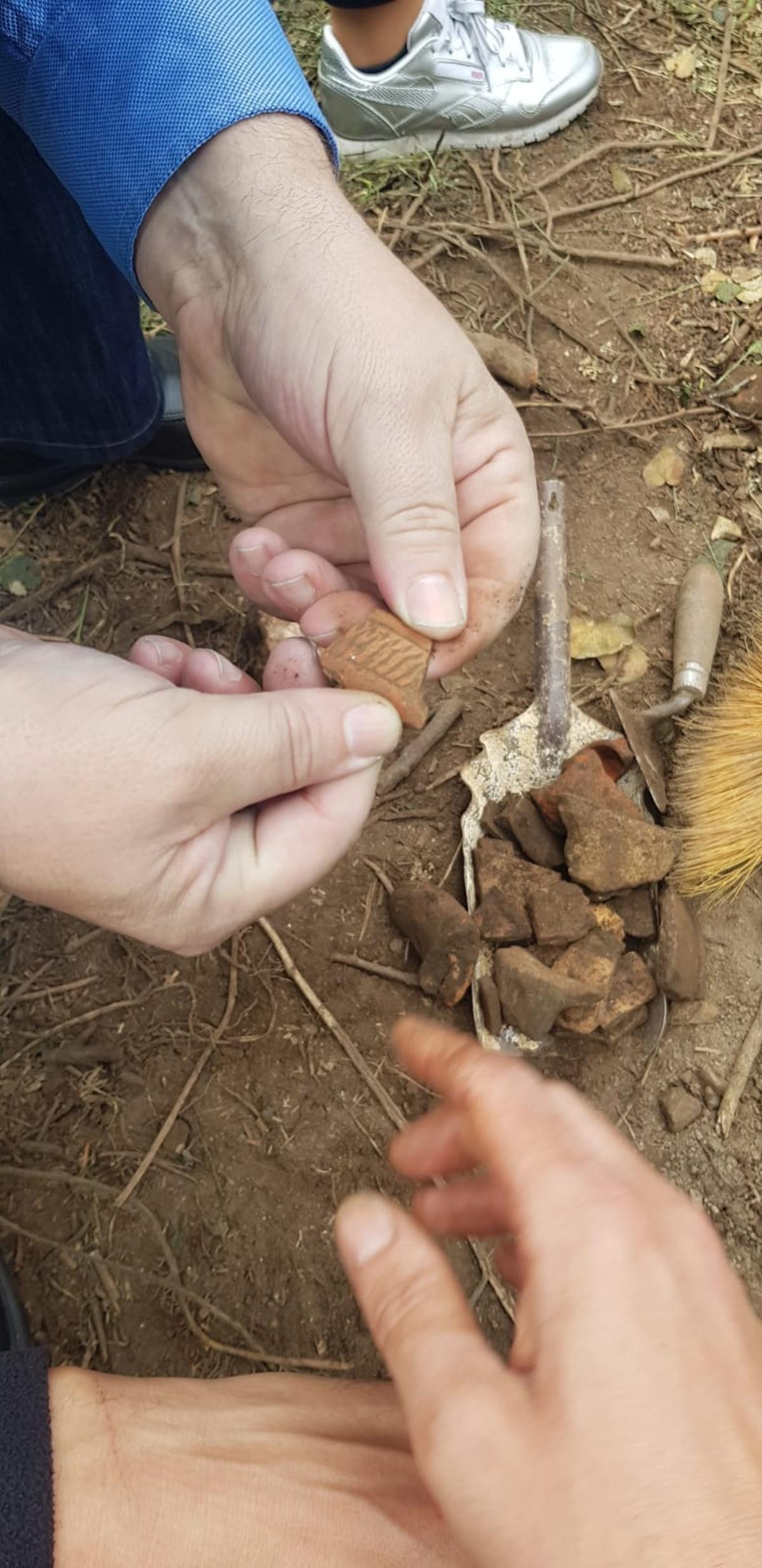 Un arqueólogo muestra una de las piezas halladas en la excavación.