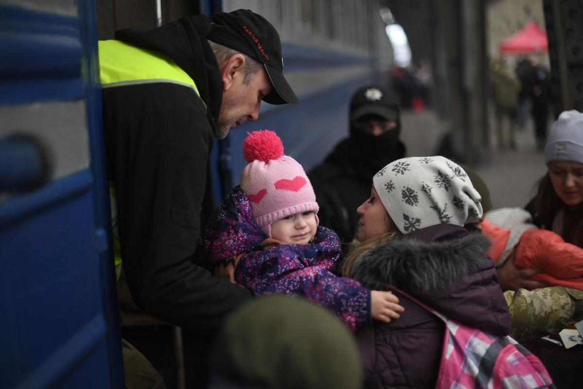 Una mujer y su hijo se disponen a subir a un tren que les llevará de la ciudad ucraniana de Leópolis hasta Polonia.