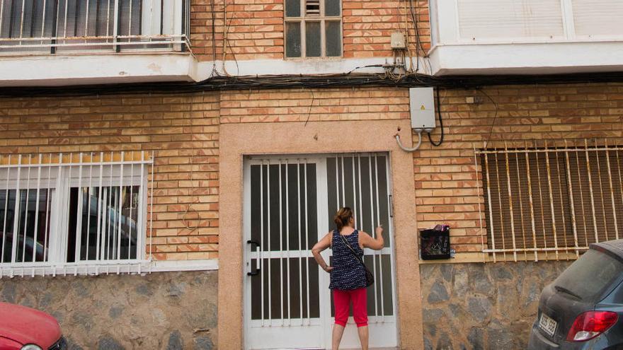 Una mujer toca al timbre de una vivienda social.