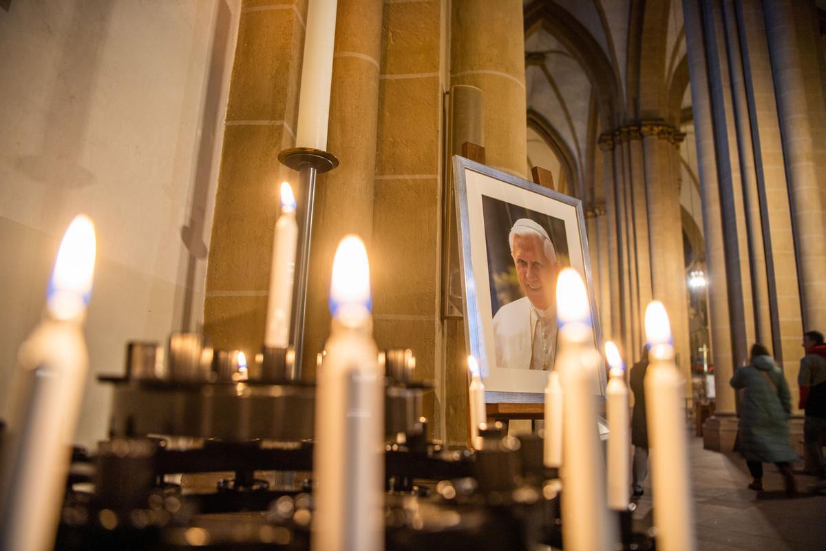 Velas junto a un retrato del papa emérito Benedicto XVI.