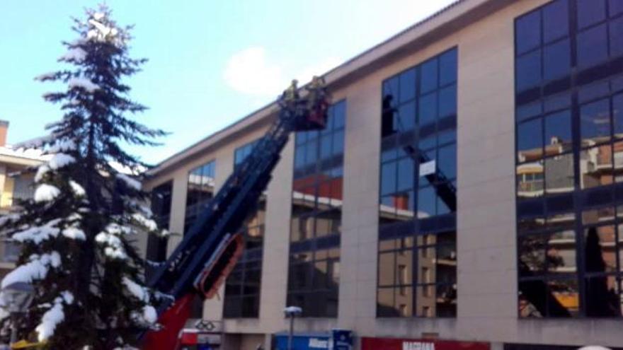 Els Bombers trenquen caramells de gel d'una teulada de Berga