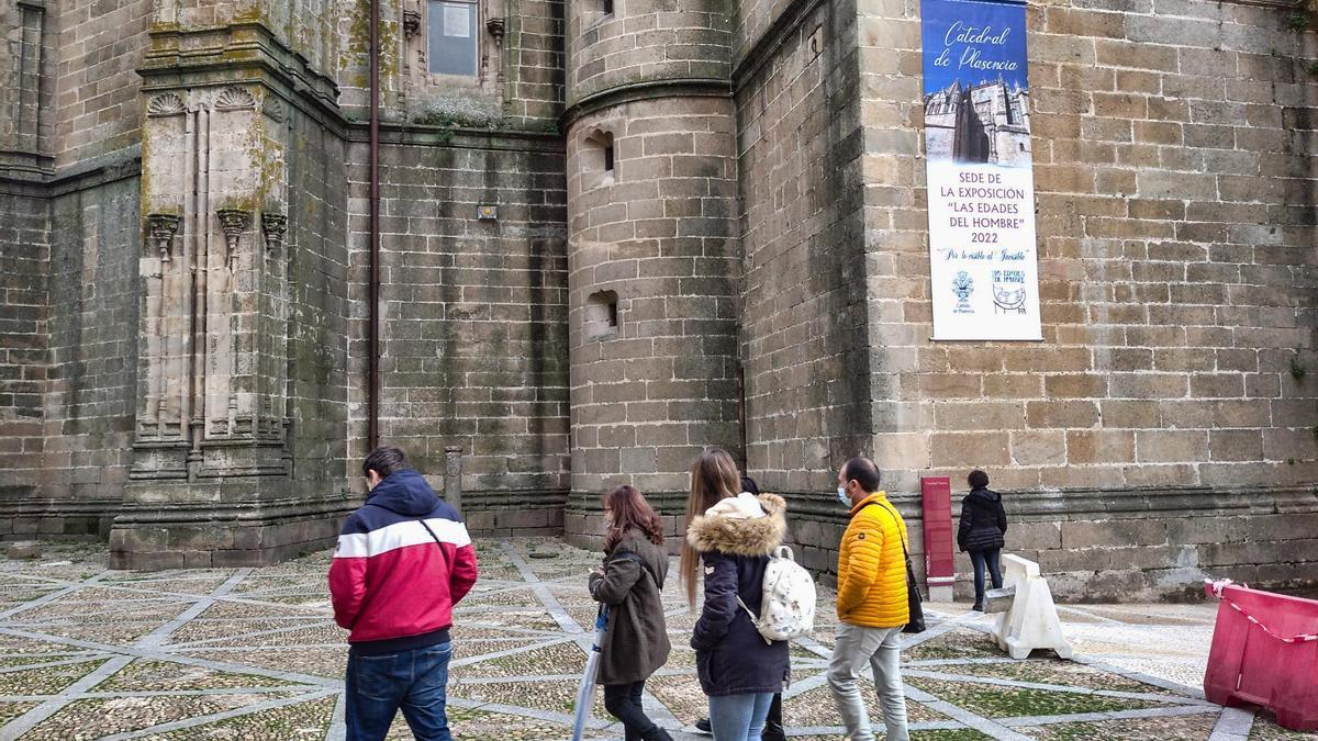 Turistas ante la catedral, con un cartel de las Edades del Hombre.