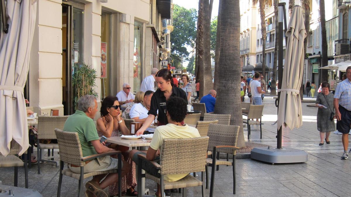 Archivo - Un camarero atienda una mesa de un bar.