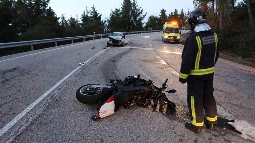 La moto en la que viajaba el fallecido y, al fondo, el turismo contra el que impactó. // Nick