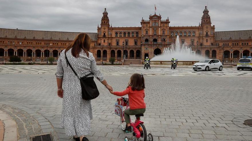 Una mujer y su hija pasean por la plaza de España de Sevilla.