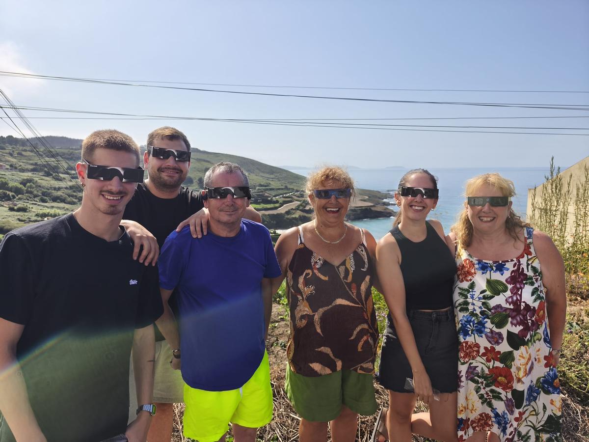 Un grupo de personas posa con las gafas preparados para disfrutar del eclipse en Caión.