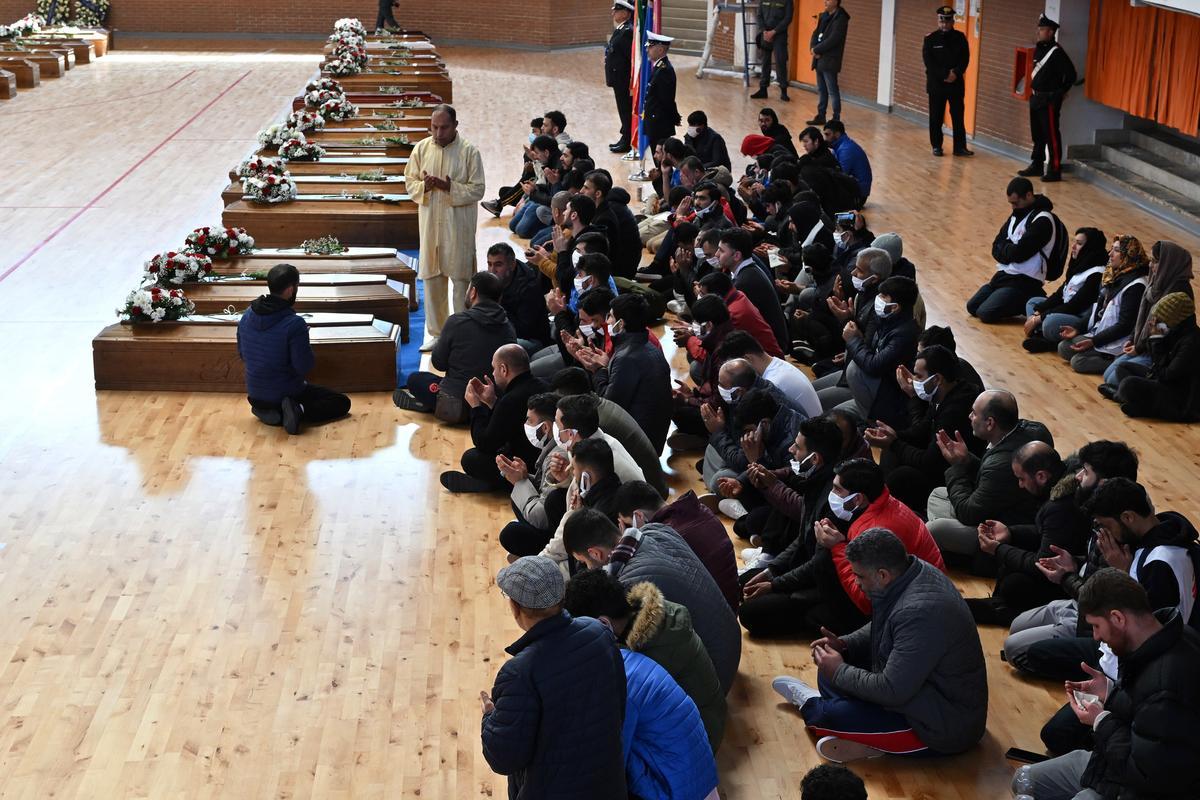 Familiares junto a los ataúdes de las 65 víctimas de un devastador naufragio de inmigrantes frente a la costa sur de Italia