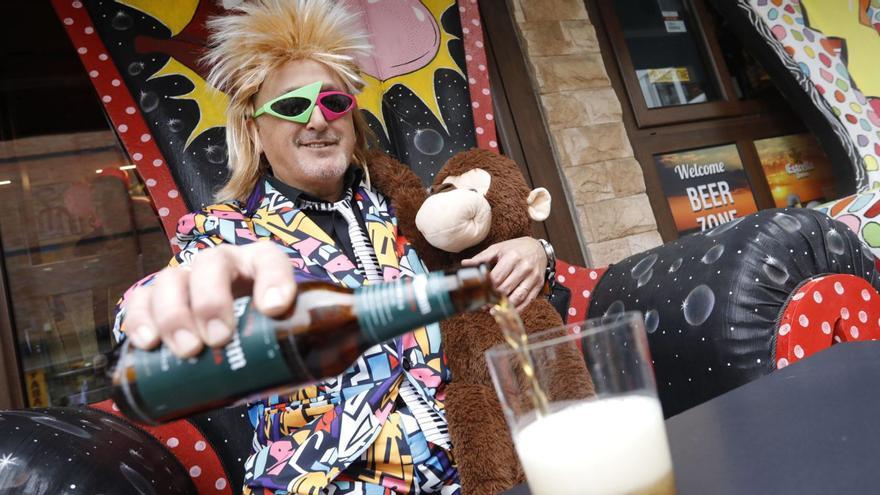 José Lobato, junto al mono «Matías», sirviéndose una cerveza en la terraza de su bar. | |  RICARDO SOLÍS