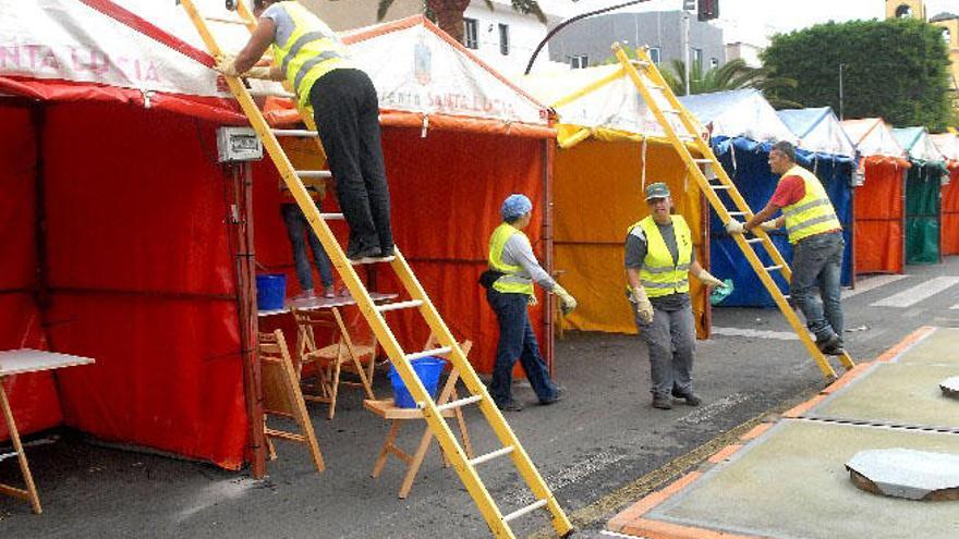 Varios empleados municipales montan las casetas de la XI Feria de Artesanía, Agricultura y Ganadería en la avenida de Ansite de Cruce de Arinaga.