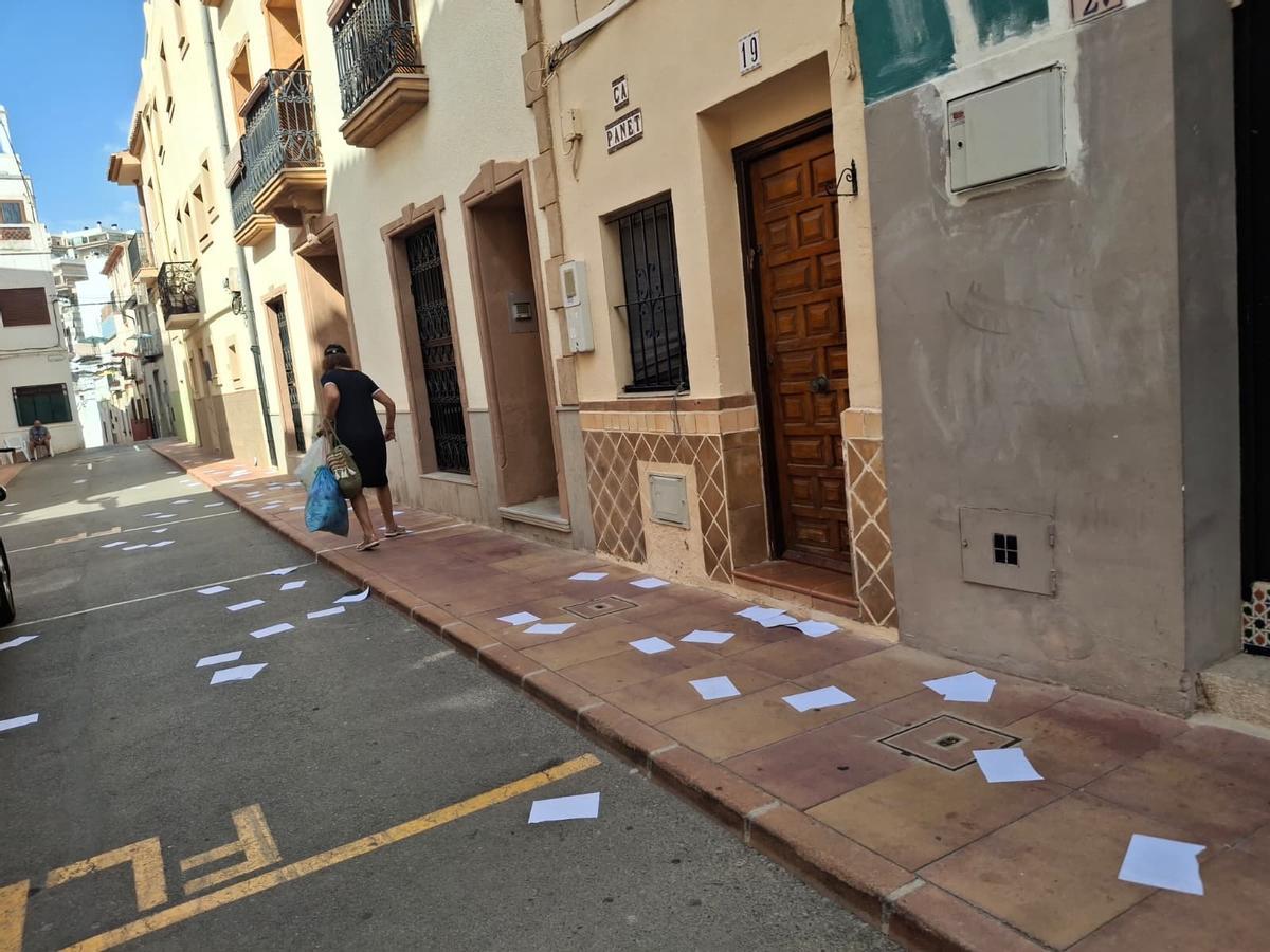 Una vecina , sorprendida al encontrar su acera y su calle salpicada de hojas en blanco